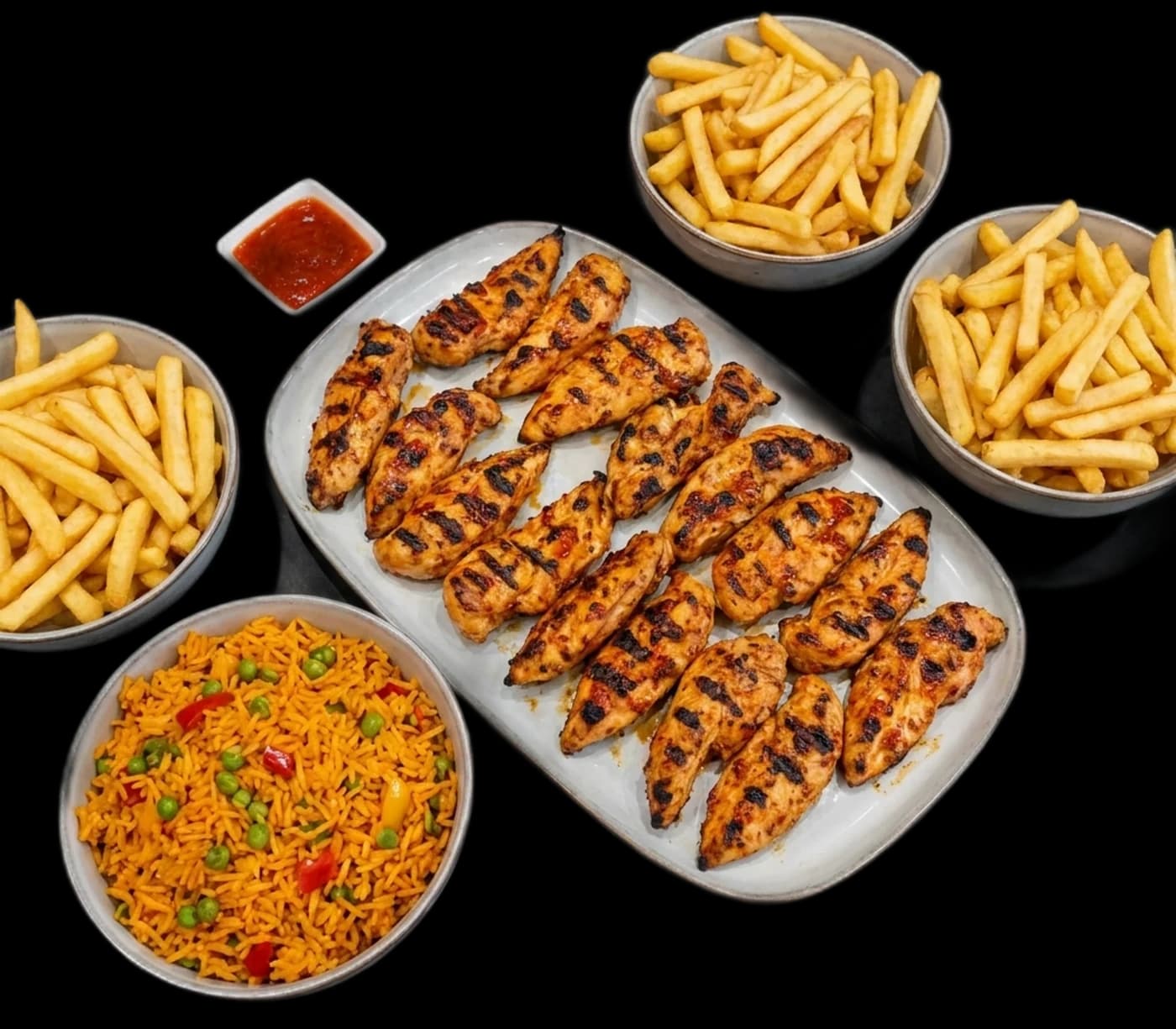 Sharing platter of peri strips, rice, fries and dips