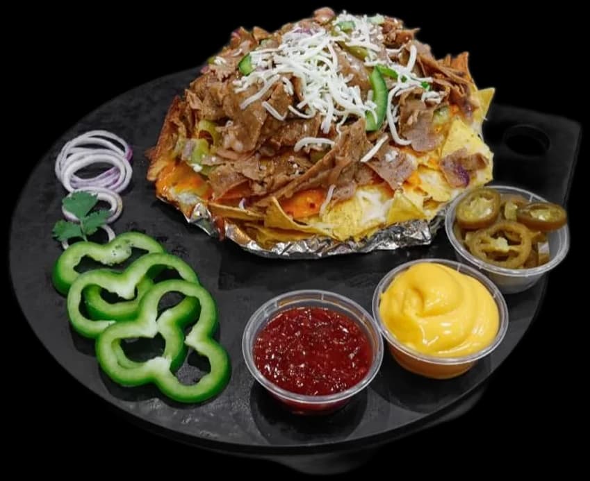 Loaded nachos with dips, jalapeños and peppers